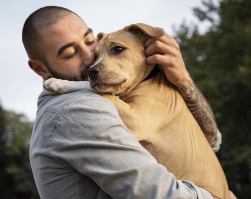 man cuddling a dog